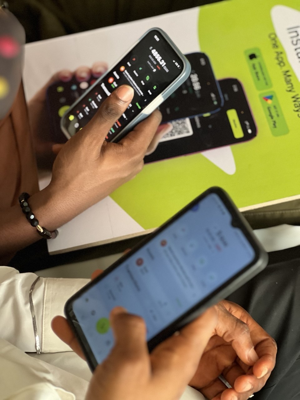 Two phones held up showing live Blip wallet balances during Money Moves Uyo
